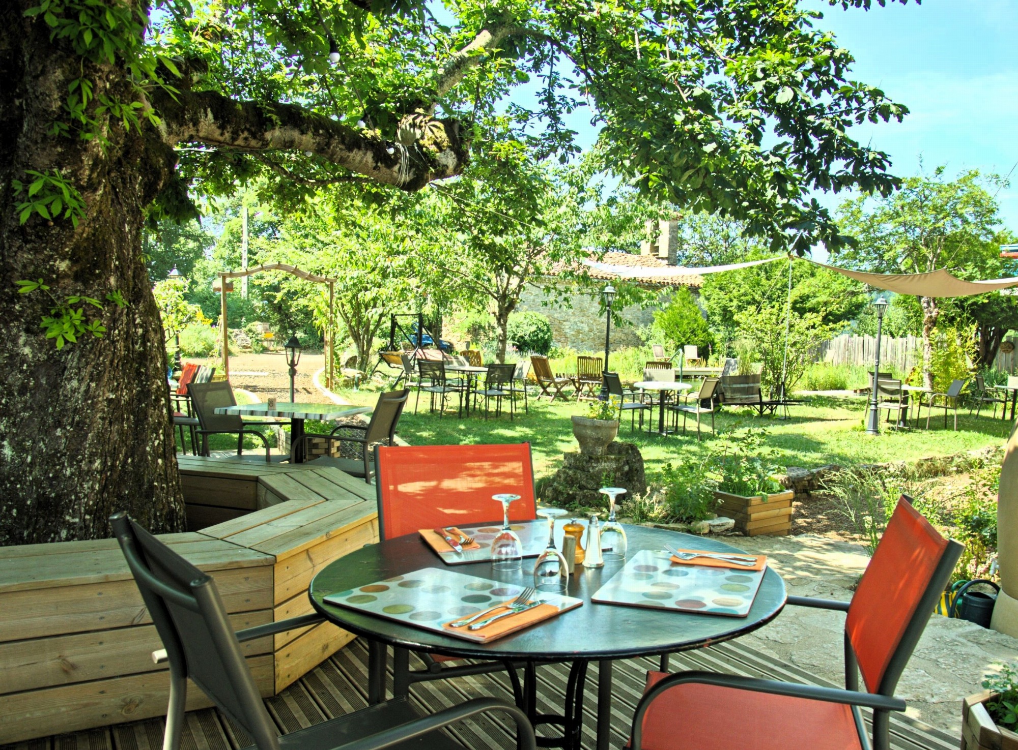 Tables en terrasse dans un jardin ombragé et paisible