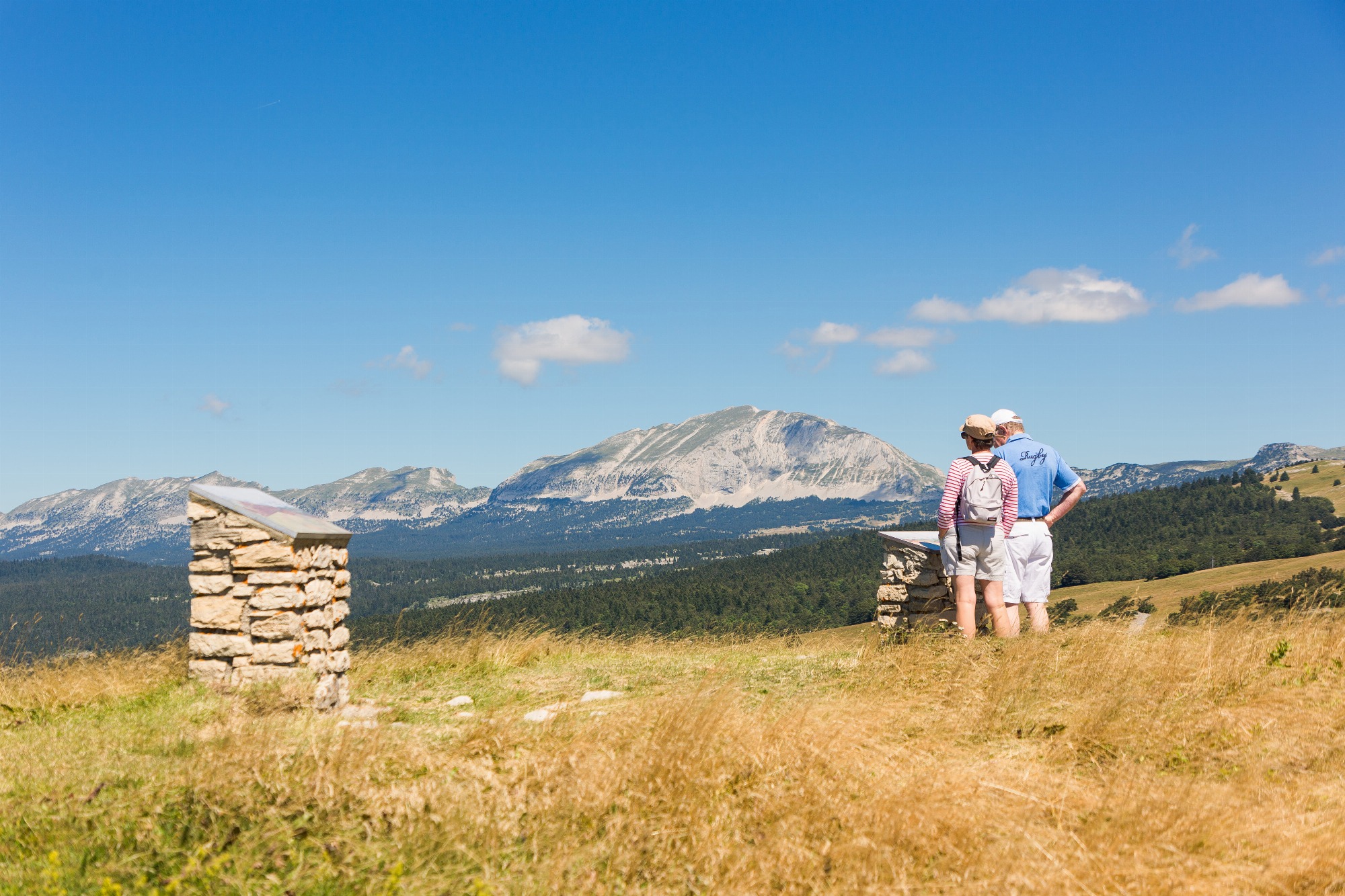 Randonneurs regardant une table d'orientation face au Grand Veymont