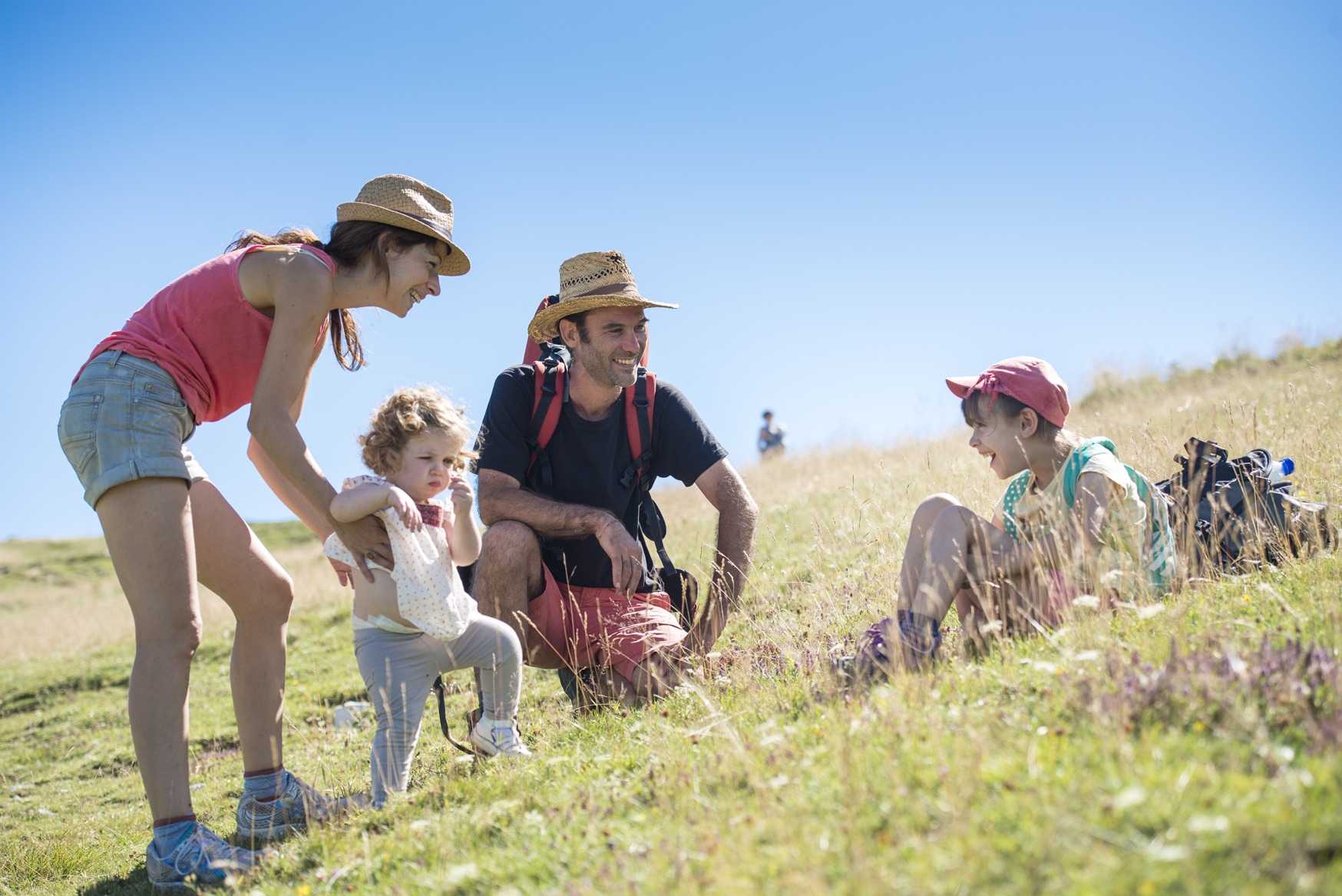 Famille qui s'est posée dans l'herbe pendant la randonnée
