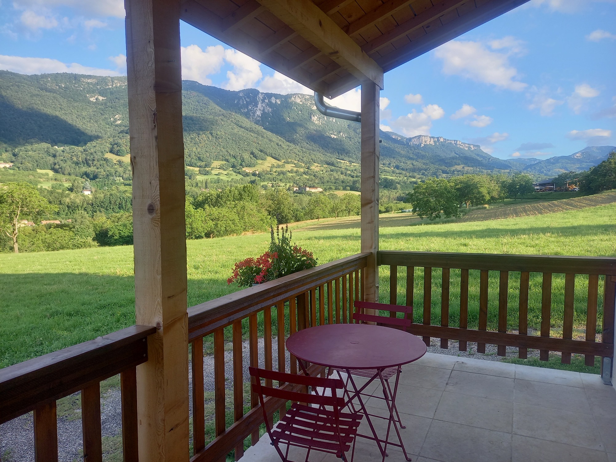 Terrasse bien exposée avec vue sur les montagnes et les prés verdoyants du Royans du Gite la Maldina à Oriol en Royans